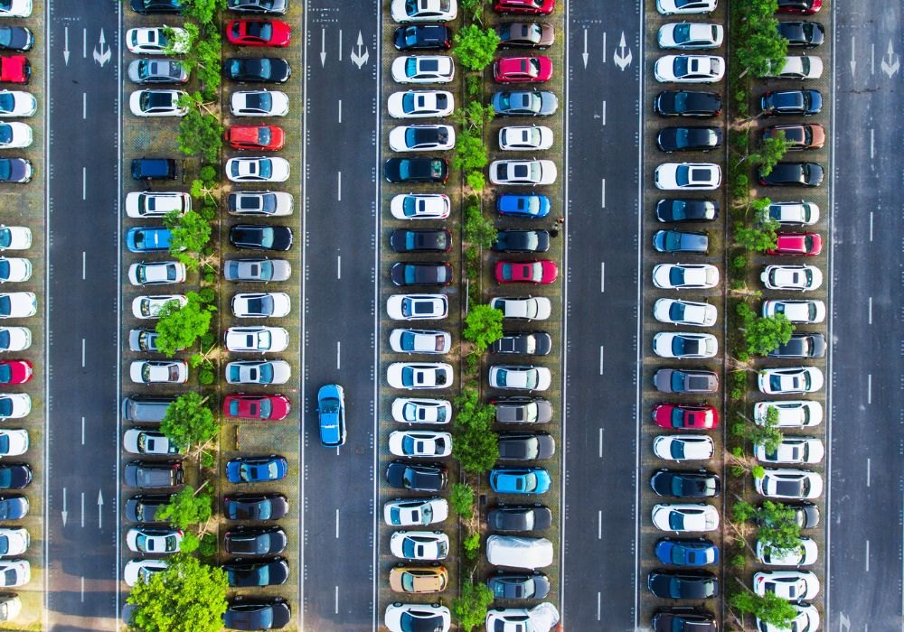 Turysta robi zdjęcie wynajętego samochodu przy zwrocie na parkingu wypożyczalni przy lotnisku
