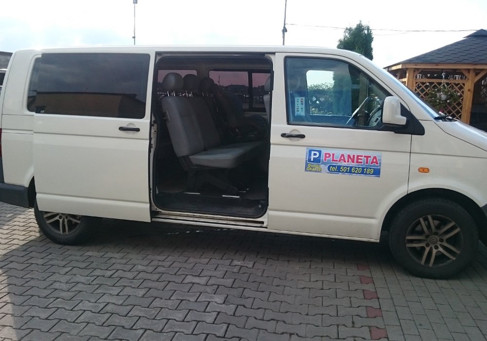 Tablica przylotów na lotnisku Katowice-Pyrzowice, pasażer czeka na transfer z lotniska na parking