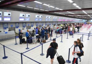 Pasażer z walizką przed terminalem lotniska Katowice-Pyrzowice przed pierwszym lotem