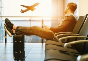 Turysta na plaży rozmawia przez telefon, przedłużając postój na parkingu przy lotnisku