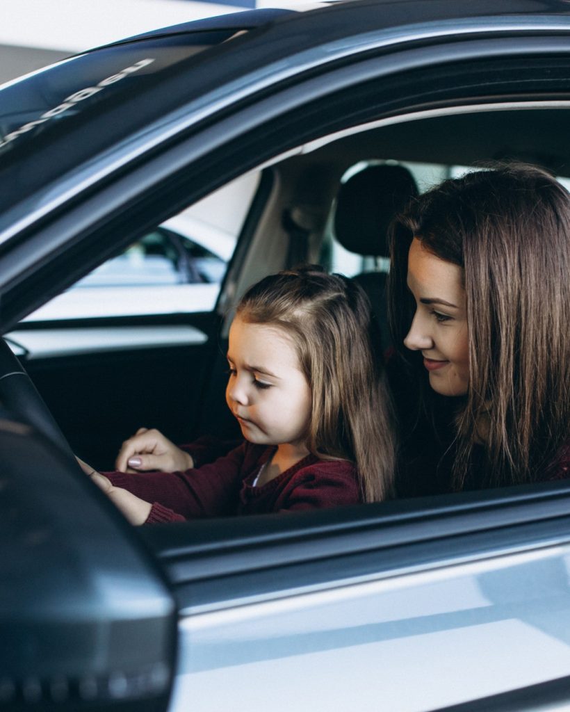young-mother-with-little-daughter-sitting-inside-car (1)-min
